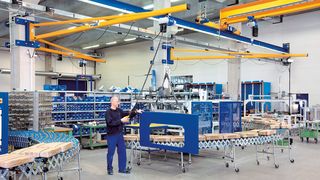 Abus-Wandschwenkkrane mit Elektrokettenzügen „ABUCompact“, die mit einer Standardwandkonsole an den Betonstützen befestigt sind, als Arbeitsplatzkrane in der unteren Bedienebene. (Bild: Abus)