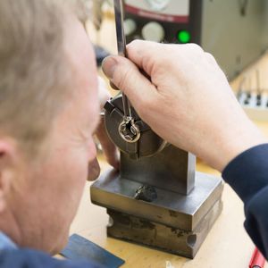 Beim Verheiraten setzt der Edelsteinfasser den Brillant in den Ring. Die Spannung im Material hält den Stein sicher und dauerhaft.