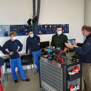 Den Auszubildenden und dem Redakteur erklärt der Technische Trainer Frank Boxler (re.) den fiktiven Arbeitsauftrag am Golf GTI.