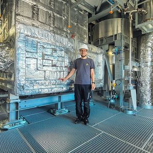 Lukas Geissbühler, Head Thermal Systems bei Synhelion, vor dem Hochtemperatur-Wärmespeicher von DAWN. (Bild:  Synhelion)