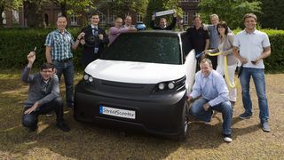 Eine Allianz von RWTH-Experten und Industrieunternehmen entwickelt den StreetScooter als serientaugliches Elektroauto – das Foto zeigt Projektmitarbeiterinnen und –mitarbeiter gemeinsam mit Leiter Professor Dr.-Ing. Achim Kampker (3. von links).  (Bild: RWTH Aachen)