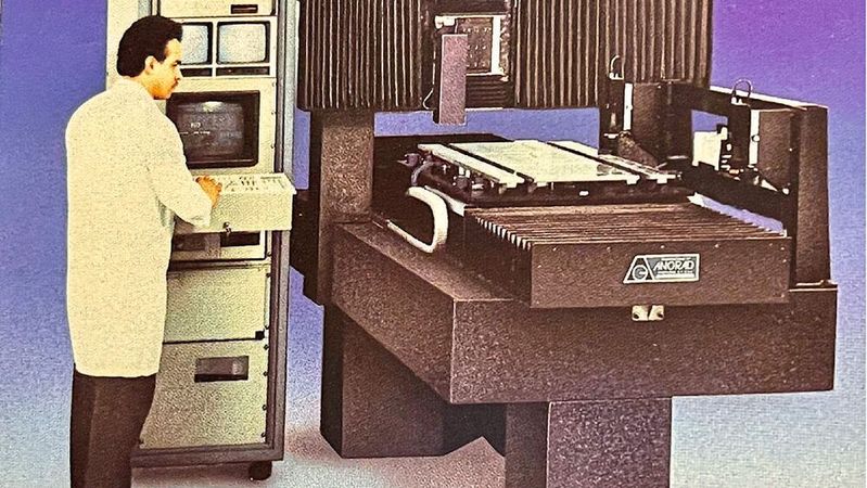 Frühe Inspektionssysteme: In den 1980er und frühen 1990er Jahren waren Anlagen zur optischen Inspektion noch extrem massiv. Kamerasysteme, präzise Positioniertische (hier von Anorad) und schrankgroße Steuerungsrechner mit Röhrenmonitoren prägten das Bild, lange bevor Smart Cameras diese Technik miniaturisierten.(Bild:  Beidelberg / CC BY-SA )