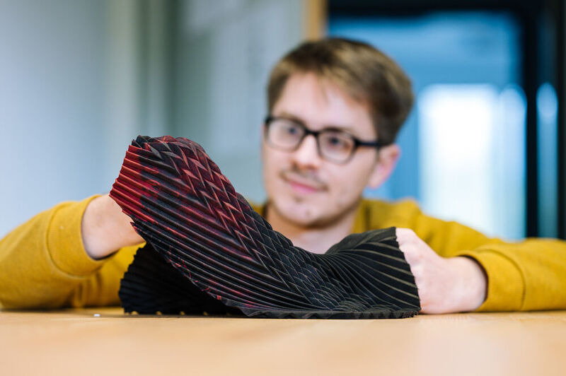 Informatiker Bruno Fruchard präsentiert ein Textil, das je nach Dehnungsgrad seine Leitfähigkeit verändert. (Universität des Saarlandes)
