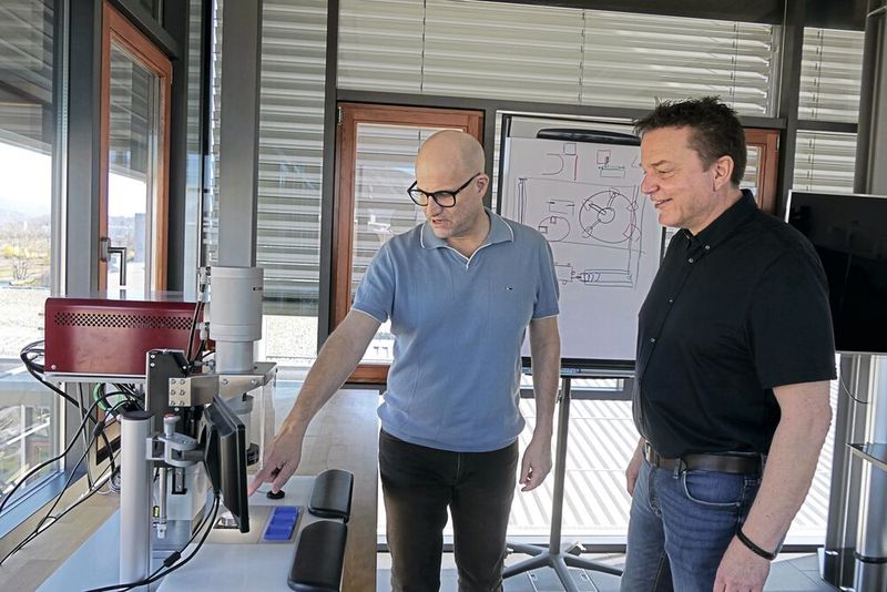 Thomas Villard zeigt Stephan Mack die Servo Presse PE20 High Precision. Sie ist die erste Maschine, die mit der Automatisierungslösung von Sigmatek ausgerüstet wurde. (Bild: Lion Communication)