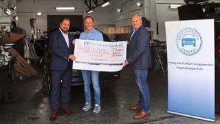 Obermeister Detlef Peter Grün (r.) und der Hauptgeschäftsführer des Kfz-Landesverbands NRW, Marcus Büttner (l.), übergaben gemeinsam den symbolischen Scheck an Bastian Bultink (Mitte) – stellvertretend für viele andere Kfz-Unternehmer in NRW.  (Bild: Kfz-Gewerbe NRW)