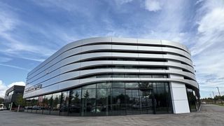 Porsche steuert bei seinem Architektur-Konzept „Destination Porsche“ nach. Die Baukosten für Händler sind in den vergangenen Jahren gestiegen, gleichzeitig haben sich neue Möglichkeiten wie etwa für die digitale Schauraumgestaltung ergeben. Jedoch ist derzeit auch der Absatz des Herstellers auf dem Heimatmarkt rückläufig, was die Investitionsmöglichkeiten der Händler bremsen dürfte. (Bild: Achter – VCG)