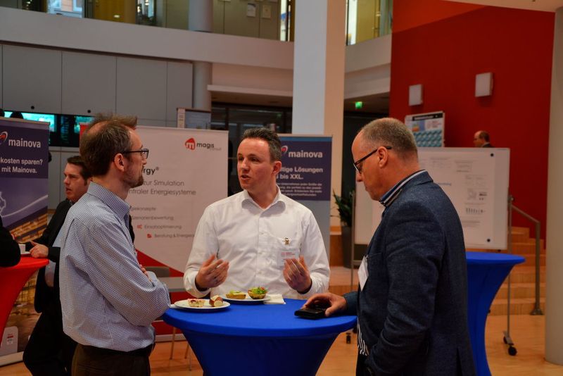Diskussion in der Kaffeepause. Im Hintergrund der Stand von Gastgeber Mainova.  (Process)