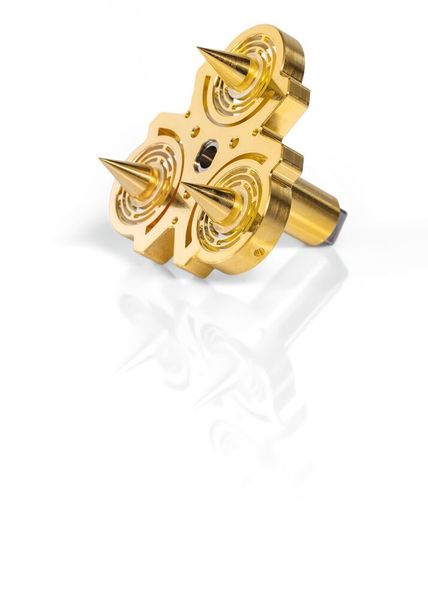 Drei kegelförmige Körperelemente aus einem 0.13mm dicken Silberträger, innen geschwärzt und außen vergoldet, sind auf einem thermischen Widerstand platziert. Darunter liegt eine Wärmesenke. Sie hat die Aufgabe für die Dauer des Messzyklus Temperaturvariationen zu verhindern.  (Telsonic)