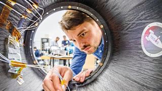 Ralf Engelhardt kontrolliert die faseroptischen Sensoren des Raketenmoduls. (Andreas Heddergott / TU München)