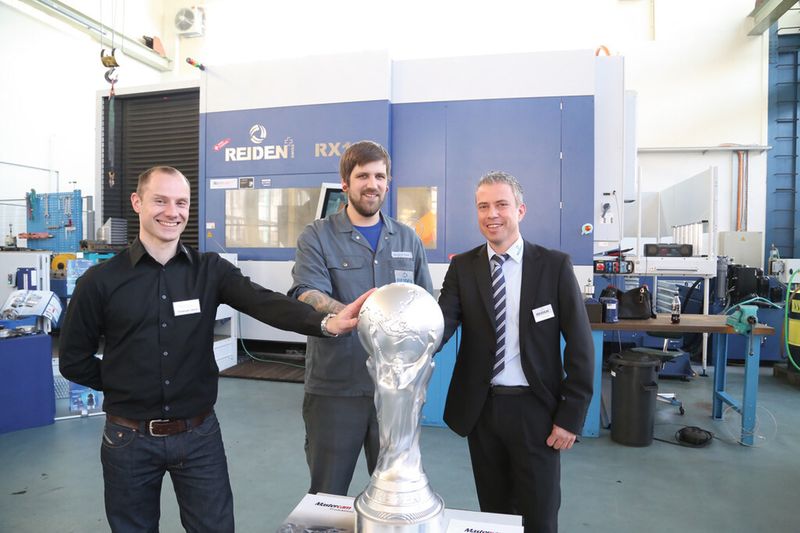Bei Reiden Technik AG konnten die Besucher den WM-Pokal  bereits zwei Monate vor der WM in der Hand halten. Gefertigt wurde er auf einer RX14. Daniel Lustenberger (Verkaufsleitung, re.) führte den SMM-Redaktor durch das Unternehmen. (Bild: Matthias Böhm)