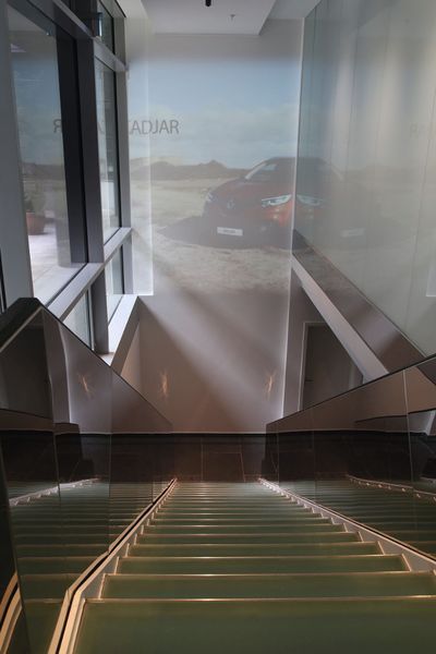 Die Wand beim Treppenabgang ist mit Filmen „bespielbar“. (Foto: Autohaus König)