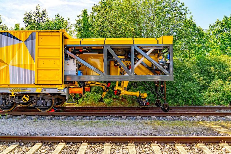 Das neue automatische Schienenreparatursystem besteht aus einem Waggon, der auf Schienen gezogen wird und mit zwei Robotern von Fanuc ausgestattet ist (rechts). Außer dem Schweißen beherrscht diese Robel-Innovation das Fräsen und Schleifen. (Bild: Robel)