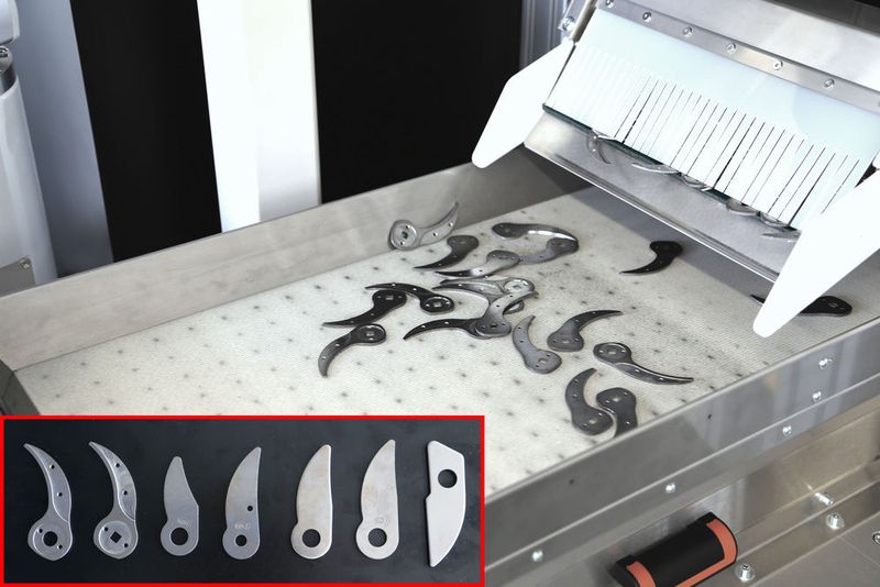 Die Stahlklingen für Scheren fallen vom Dosierbunker in chaotischer Lage und Orientierung auf einen Lesetisch. (Vollrath)