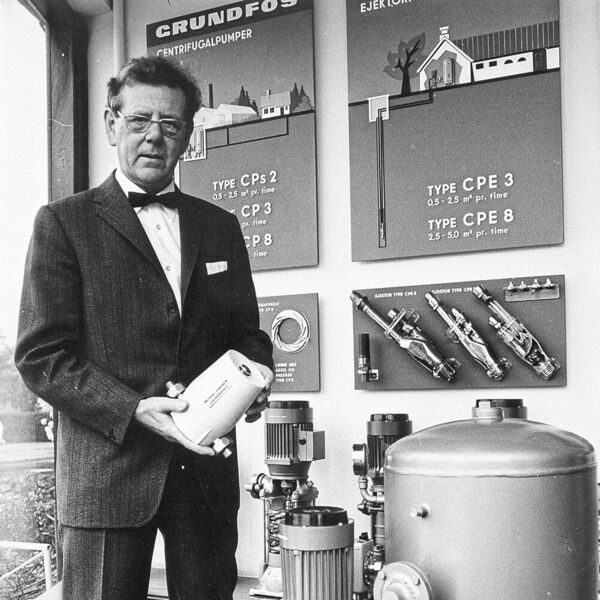 1958: Poul Due Jensen, der Unternehmensgründer von Grundfos; in den Händen hält er die erste Heizungsumwälzpumpe VP32, im Hintergrund und rechts im Bild sind mehrstufige CP-Pumpen in Segment-Bauweise zu sehen (Grundfos)