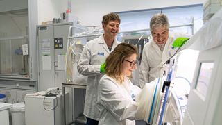 Förderung eines neuen Forschungsprojekts: HIRI-Direktor Prof. Dr. Jörg Vogel (l.) und Dr. Gunther Schunk, Vorstandsvorsitzender der Vogel Stiftung, mit Stipendiatin Valentina Cosi an der anaeroben Werkbank im Labor. (Bild: HIRI / Luisa Macharowsky)