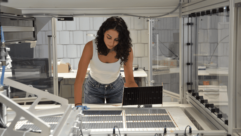 Die Projektleiterin am Fraunhofer ISE, Najwa Abdel Latif kontrolliert die verschalteten Solarzellen am Schindel-Matrix-Stringer des Fraunhofer ISE.(Bild:  Fraunhofer ISE / Sophia Bächle)