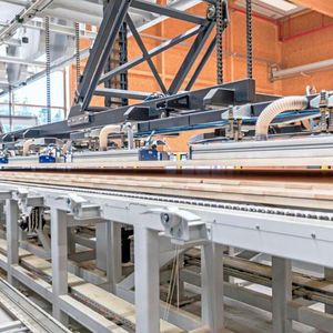 Das zweite Vakuumportal legt bei Holzbauwerk Schwarzwald den sogenannten Presskuchen auf den  Beleim- und Zuführtisch, der sich vor der BSP-Presse befindet.(Bild:  J. Schmalz)