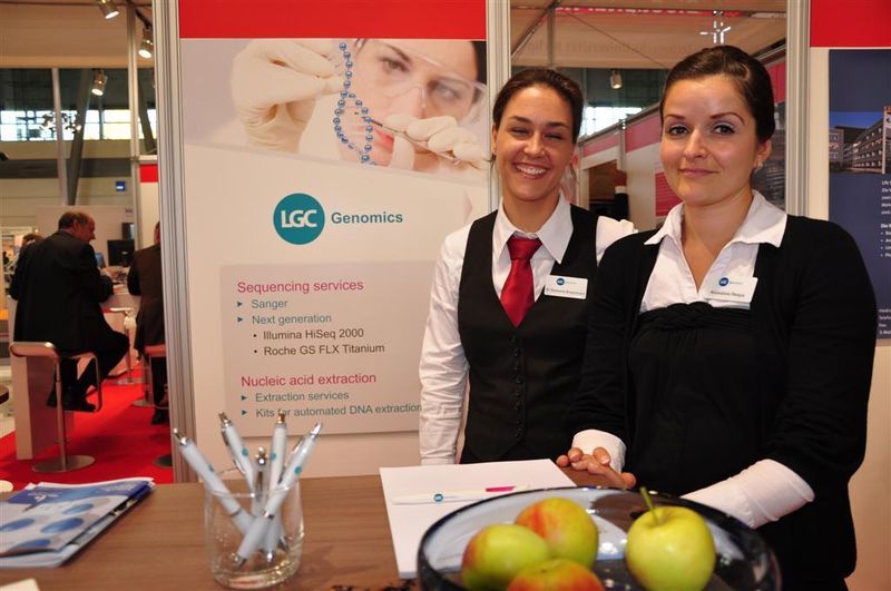 Dr. Stephanie Bovensmann (links) und Annedore Respa am Messestand von LGC Genomics. Das Unternehmen bietet DNA-Sequenzierung, die Aufreinigung von Nukleinsäuren und molekularbiologische Dienstleistungen an. Neu im Portfolio des Dienstleisters ist ein Prepaid MTP Sequenzierungsservice. (Archiv: Vogel Business Media)