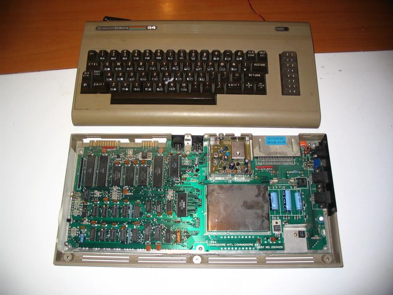 Blick auf das Board eines C64. Da der platzsparende Tastaturrechner unter hohem Zeitdruck entwickelt wurde, bekam der Computer eine umlackierte Variante desselben Gehäuses spendiert, dass schon sein Vorgänger VIC20 besessen hatte. (Wikimedia Commons / Dake, CC-BY-SA 3.0)
