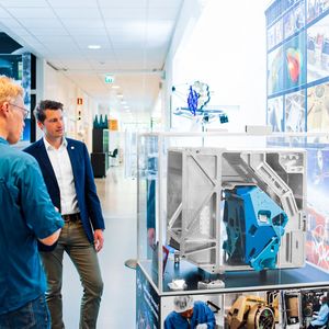 Thomas Wijnen, Instrumentation Coordinator (Nova), Iggy Rolando (Grob), und Niels Tromp, System und Engineer (Nova), im Gespräch über die Universalfräsmaschine G750. Im Schaukasten Bauteile für das Extremely Large Telescope ELT, die jetzt auf der hochpräzisen Grob-Maschine prozesssicher gefertigt werden können.(Bild:  Nova)