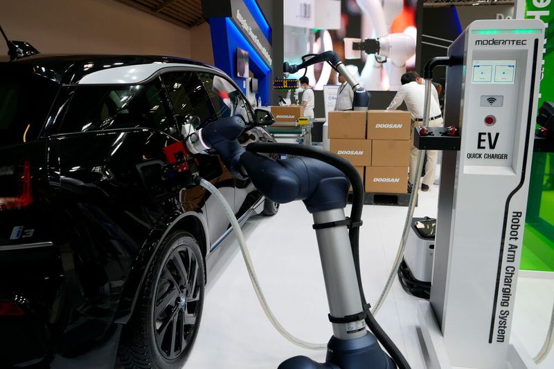 Auch das fällt in den Bereich Service: bei Doosan Robotics versorgt ein Roboter ein Elektroauto mit Strom. Die Maschine erkennt dabei die Position des Fahrzeugs und des Ladeanschlusses und kann dadurch den Ladestecker ein- oder ausstecken. (Bild: Sandro Kipar)