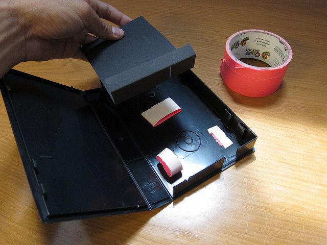 An imaginary line directly from the slit should intersect the lens. You may have to adjust the angle of the webcam later, once you start collecting spectra. Tape or glue your black card in place, firmly abutting the wall with the opening. You may have to add black tape (gaffe tape works well) to absorb reflections if your box is very shiny or has light leaks. (Bild: PLOTS/CC BY 2.0)