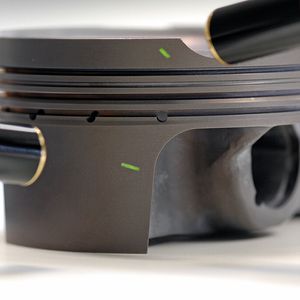 Chemisch abgeschiedene Nickelschicht mit PTFE-Markern auf einem Aluminiumkolben.