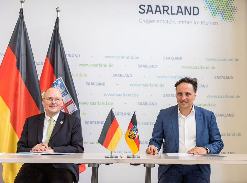 Der Präsident des BSI, Arne Schönbohm, (links) und der saarländische CIO, Ammar Alkassar, (rechts) unterzeichnen die Kooperationsvereinbarung (Staatskanzlei/Pf)