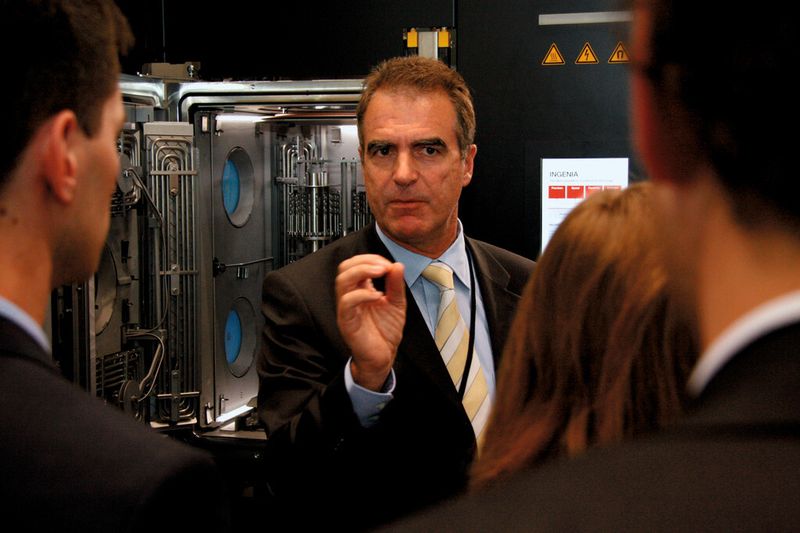 Dr. Hans Brändle, CEO, Oerlikon Coating erklärt den Teilnehmern des Swissmem Young People Program die Funktion der Ingenia Beschichtungsanlage. (Bild: Matthias Vogel)