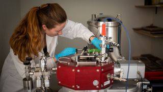 Johanna Byloff analysiert die Proben an der Beschichtungsmaschine des Empa-Spin-offs Swiss Cluster vor. (Bild: Empa)