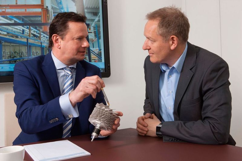 Im Beratungsgespräch mit einem Kunden. Bei dem Bauteil handelt es sich um einen Rotor für Turbomolekularpumpen, der mit Keplan-Coat weiß beschichtet wurde. (AHC)