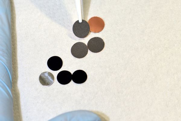 Akkualterung: Proben von Anodenmaterial (grau) und Kathodenmaterial (schwarz) (Bild: Andreas Battenberg / TU Muenchen)
