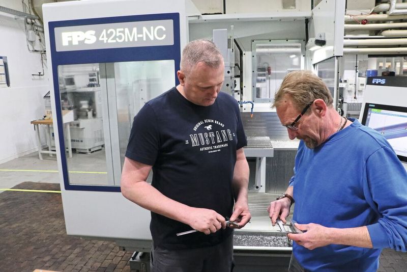 Nach erfolgreichem Programmablauf prüft der Ausbildungsmeister Thorsten Schmidt das vom Umschüler Sergej Selenski gefertigte Werkstück … und zeigt sich mit dem Ergebnis sehr zufrieden. (Bild: FPS Werkzeugmaschinen)