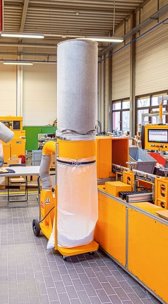 Das fahrbare Radialgebläse mit Staubfiltersack erfasst die beim Schneiden anfallenden Faserspäne unkompliziert. (Bild: Esta)