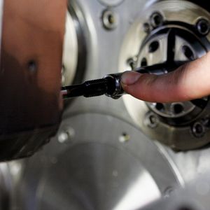 Blick auf den Fertigungsprozess ab Stange und auf die aufgeschnittene Gewindebuchse. Der Gewindeschneider muss zirka 20 mm in das Werkstück eintauchen, bevor es ans Zerspanen geht. Dank Sackloch (ab Stange) und 20-bar-Hochdruckkühlung werden die Späne sicher aus der Prozesszone nach hinten abgeführt.
