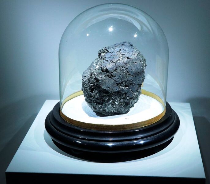 The Orgueil carbonaceous meteorite, a scientific treasure that fell in 1864 in southwest France. The main mass of the meteorite can be seen at the meteorite exhibit at the Muséum National d’Histoire Naturelle in Paris until January 2019. The stand on which the meteorite is displayed is about 30 cm across (University of Manchester/ K.H. Joy)