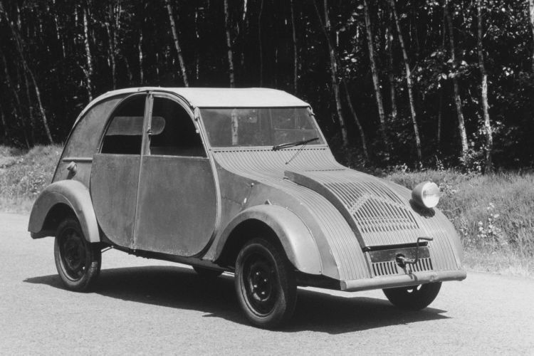 Citroën-Direktor Pierre-Jules Boulanger erteilte 1934 den Auftrag, einen minimalistischen Kleinwagen zu entwickeln. Die Anforderungen lauteten angeblich: „Entwerfen Sie ein Auto, das Platz für zwei Bauern in Stiefeln und einen Zentner Kartoffeln oder ein Fässchen Wein bietet, mindestens 60 km/h schnell ist und dabei nur drei Liter Benzin auf 100 Kilometer verbraucht. Außerdem soll es selbst schlechteste Wegstrecken bewältigen können und so einfach zu bedienen sein, dass selbst eine ungeübte Fahrerin problemlos mit ihm zurechtkommt. Es muss ausgesprochen gut gefedert sein, sodass ein Korb voll mit Eiern eine Fahrt über holprige Feldwege unbeschadet übersteht. Und schließlich muss das neue Auto wesentlich billiger sein als unser ,Traction Avant‘. Auf das Aussehen des Wagens kommt es dabei überhaupt nicht an.“ (PSA)