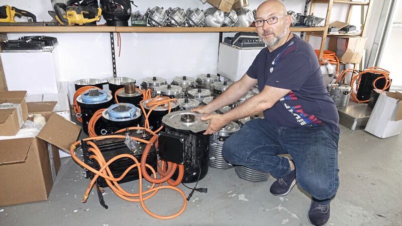 Heiko Fleck mit dem einen Herzstück seiner Umbausätze, den Asynchronmotoren. Die bezieht er mittlerweile ausschließlich „made in Germany“.  (Dominsky/»kfz-betrieb«)
