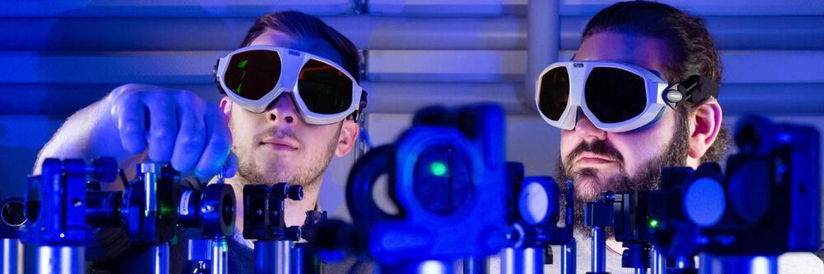 Die Doktoranden Paul Herrmann (l.) und Sebastian Klimmer experimentieren an einem Laser-Versuchsaufbau an der Universität Jena. Dank 2D-Materialien fließen Informationen bis zu 1.000-mal schneller als mit Strom. (Bild: Jens Meyer/Uni Jena)