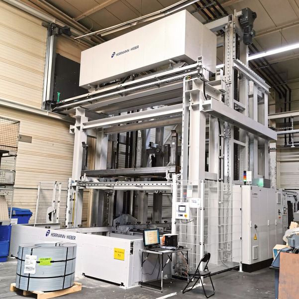 Der Übergabeturm mit Kettenlift in der Nachbarhalle ist via Hochbrücke samt Shuttle an das Lager angeschlossen. Er verfügt über mehrere Pufferplätze sowie zwei Ausschleusungsbereiche. (Bild: Klaus Vollrath)