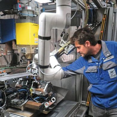 Ein kollaborativer Roboter unterstützt die Mitarbeiter von Meleghy Automotive beim Einlegen von Blechteilen in eine Schweißpresse – sicher, ergonomisch und effizient. So werden Prozessstabilität und Arbeitsergonomie im Fertigungsalltag weiter verbessert.  (Bild: Igus GmbH)