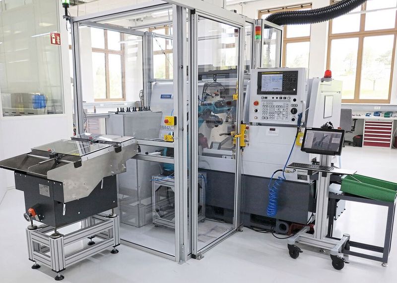 Miyano BNA-42CY5 zum Rändeln von Klingenrohlingen. Im Vordergrund links die Roboterzelle mit vorgeschaltetem Vereinzelungsförderer, rechts der Ablagekorb nach der Bearbeitung. (Bild: KSKOMM)