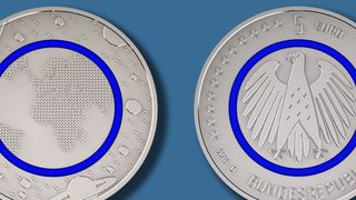 Der blaue Polymerring der Sammlermünze soll die Erdatmosphäre symbolisieren. (Bild: Bundesamt für zentrale Dienste und offene Vermögensfragen (BADV))