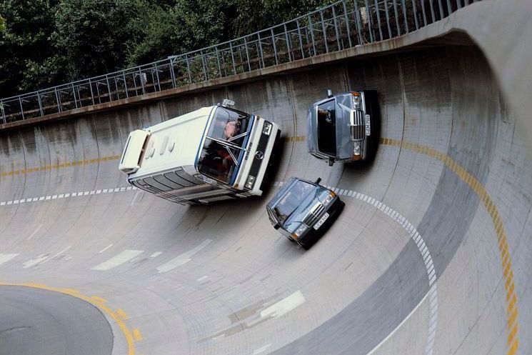 1984: In der Steilkurve der Einfahrbahn zeigen sich eine Limousine der Baureihe 201, eine S-Klasse-Limousine der Baureihe 126 und ein O 303 Reiseomnibus. Bis auf 90 Grad erstreckt sich die Steilwandkurve hier. (Daimler AG)