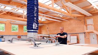 Der Vakuum-Schlauchheber Jumbo-Flex 300 von Schmalz soll schwere Holzplatten mühelos aufnehmen und beschickt die Zuschnittmaschine bei Ziehli schnell und ergonomisch. (Bild: J. Schmalz)