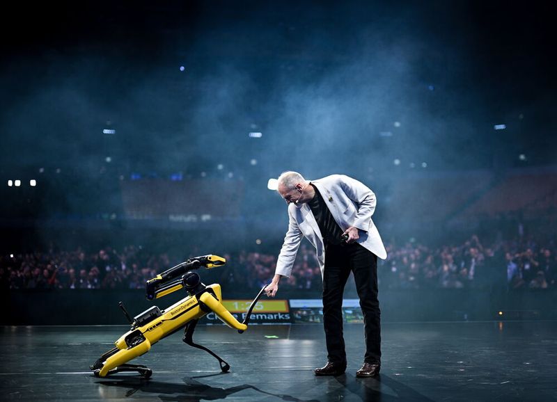 Robert Playter, CEO bei Boston Dynamics, mit dem vierbeinigen, sensorreichen, autonomen Inspektionsroboter Spot, auf der Hauptbühne der MEO-Arena des Web Summits im November 2025 in Lissabon. (Bild: ©SPORTSFILE)