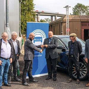 Obermeister Stefan Odenthal (6. v. l.) überreicht den Lehrkräften des Kfz-Teams – Michael Smolarek (5. v. l.) sowie Andreas Perske und Raoul Larisika – die Schlüssel für das neue E-Auto. (Bild:  Friedsam GmbH Werbeagentur)