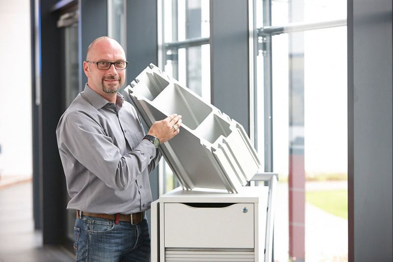 Klaus Hermes, Marketingleiter bei Rollon, demonstriert die Dimensionen eines Tecline-Rail­Systems für schwere Lasten. Die integrierten Nuten des Profils bieten eine
Montagemöglichkeit für externe Komponenten. (Rollon)