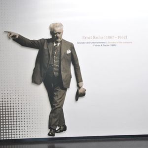 „Hier geht's lang!“: Der Firmengründer Ernst Sachs weist den Weg in die Ausstellung, die in dem einstigen Industriebau aus den sechziger Jahren ein passendes Flair findet.(Foto:  Dominsky)