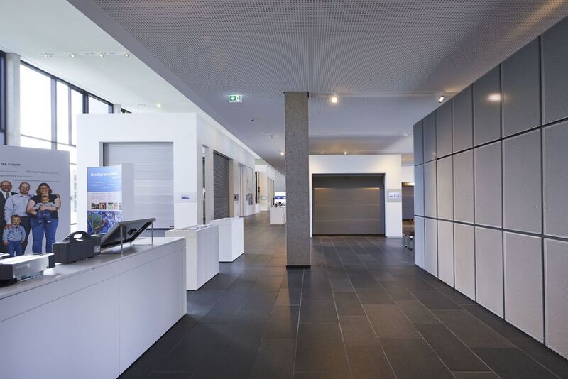 Im Erdgeschoss befindet sich auf der rechten Seite die Ausstellungsfläche der Hörmann-Garagentore. Links sind Produkte des Bereichs Industrietore und Verladetechnik ausgestellt. (Bild: Hörmann)